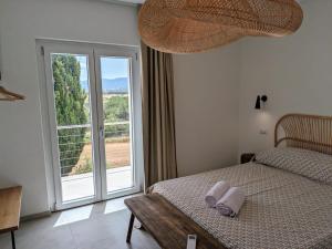 ein Schlafzimmer mit einem Bett und einem großen Fenster in der Unterkunft Agreen Country House in Olbia