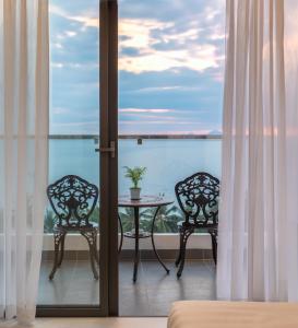 d'un balcon avec une table et deux chaises. dans l'établissement Bluebay Hotel, à Nha Trang