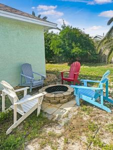 a group of three chairs and a fire pit at Beautiful House Sleeps 12 - Hot Tub - Breakfast - Walk to Beach in Panama City Beach