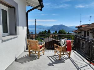 d'un balcon avec deux chaises et une vue sur les montagnes. dans l'établissement Appartamenti Luna - Stresa, à Stresa