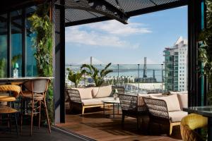 a patio with chairs and tables and a view of the ocean at Tivoli Oriente Lisboa Hotel in Lisbon