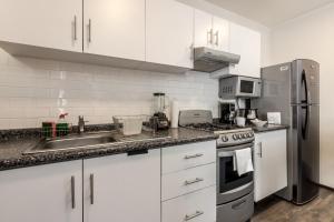 a kitchen with white cabinets and a stainless steel refrigerator at OM 686 URBAN LOFTS Narvarte in Mexico City