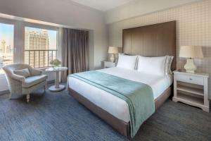 a hotel room with a bed and a chair and a window at Tivoli Oriente Lisboa Hotel in Lisbon