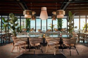 a restaurant with tables and chairs with a view of the ocean at Tivoli Oriente Lisboa Hotel in Lisbon