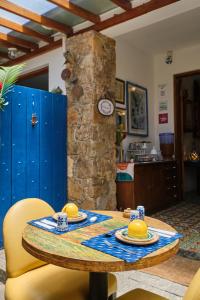 mesa de comedor con sillas amarillas y reloj en Pousada Pontal Gardens, en Paraty