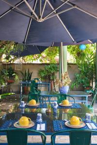 una mesa con platos de comida bajo una sombrilla en Pousada Pontal Gardens, en Paraty