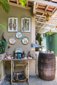 una mesa y un barril con placas en la pared en Pousada Pontal Gardens, en Paraty