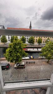 een raam met uitzicht op een parkeerplaats met auto's bij Beautiful Townhouse in Kopenhagen