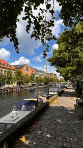 een boot is aangemeerd in een rivier met gebouwen bij Beautiful Townhouse in Kopenhagen