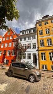 een zilveren auto geparkeerd voor sommige gebouwen bij Beautiful Townhouse in Kopenhagen