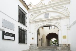 una entrada a un edificio blanco con un arco en Hospes Palacio del Bailio, a Member of Design Hotels, en Córdoba