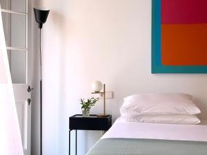 una camera da letto con un letto e un dipinto sul muro di Fragile Hotel a Ciutadella