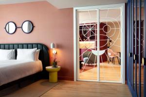 um quarto com uma cama e uma porta de vidro deslizante em art'otel London Battersea Power Station, Powered by Radisson Hotels em Londres