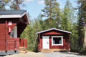 une petite cabine avec une porte blanche dans les bois dans l'établissement Crow Creek Cabins, à Inari