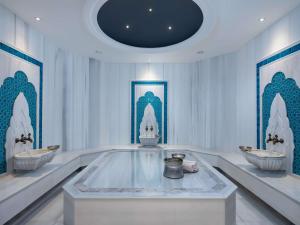 a white room with three sinks and a ceiling at Sofitel Istanbul Taksim in Istanbul