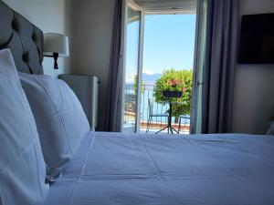 a bedroom with a bed with a view of a balcony at Sempione Boutique Hotel in Stresa