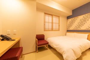 1 dormitorio con cama, escritorio y teléfono en Onyado Nono Asakusa Natural Hot Spring, en Tokio