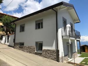 une maison blanche avec un balcon dans une rue dans l'établissement Appartamenti Luna - Stresa, à Stresa