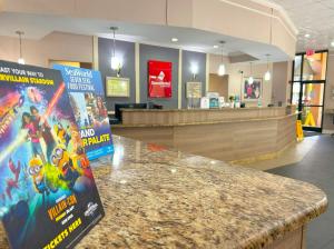 a lobby with a counter with a movie sign on it at Hotel SonoHotel By Monreale IDrive in Orlando