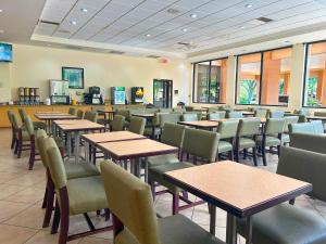 a restaurant with tables and chairs in a cafeteria at Hotel SonoHotel By Monreale IDrive in Orlando