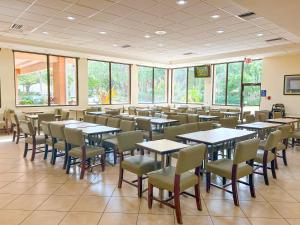 a dining room with tables and chairs and windows at Hotel SonoHotel By Monreale IDrive in Orlando