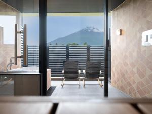 a bathroom with two chairs and a view of a mountain at Mt Fuji View and Private Sauna Ryokan Shizuku in Yamanakako