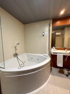 a bathroom with a large tub and a sink at Turia Granada in Granada