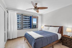 a bedroom with a bed with a ceiling fan and a window at 2 Bedrooms Unit OceanFront Resort The Alexander in Miami Beach