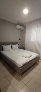 a bed with white sheets and pillows in a room at Mediterranean Sea View in Ashqelon