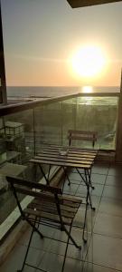 a table and bench on a balcony with the ocean at Mediterranean Sea View in Ashqelon