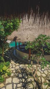 een resort met een rieten parasol en een zwembad bij Amnaya Resort Nusa Dua in Nusa Dua