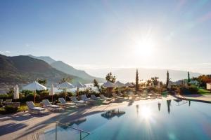 - une piscine dans un complexe avec des chaises et des parasols dans l'établissement A-ROSA Gardasee, à Salò