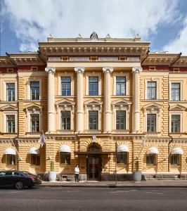 a large yellow building with a man standing in front of it at The Hotel Maria - Preferred Hotels & Resorts in Helsinki