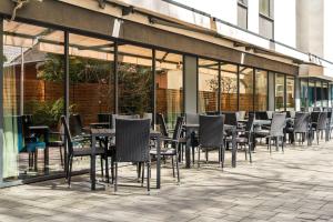 a row of tables and chairs in front of a building at Hampton by Hilton Cluj-Napoca in Cluj-Napoca