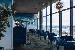 una sala da pranzo con tavoli, sedie e finestre di Clarion Hotel Helsinki a Helsinki