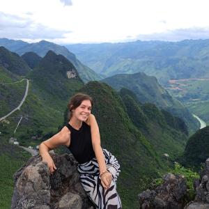 a woman sitting on a rock in the mountains at Homestay field - bungalow, Ha giang loop tour, motorbikes rental in Ha Giang