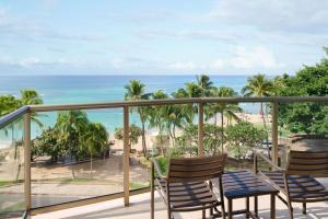 a balcony with chairs and a view of the beach at Aston Waikiki Circle Hotel in Honolulu