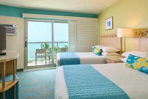 a hotel room with two beds and a balcony at Aston Waikiki Circle Hotel in Honolulu