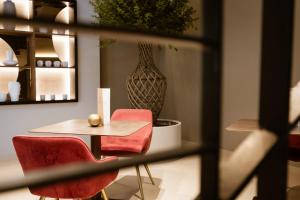 a table and chairs in a room with a vase at Ananea Tropea Yachting Resort in Tropea