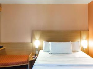 uma cama num quarto de hotel com duas luzes acesas em ibis Strasbourg Centre Historique em Estrasburgo