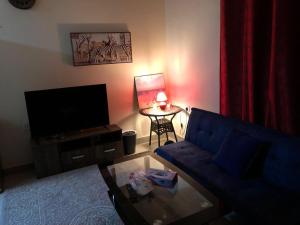 - un salon avec un canapé bleu et une table dans l'établissement Premium Furnished studio, à Charjah