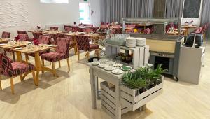 a restaurant with tables and chairs and a counter with dishes at Magnuson Hotel Sandy Lodge Newquay in Newquay