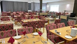 a dining room with wooden tables and chairs at Magnuson Hotel Sandy Lodge Newquay in Newquay