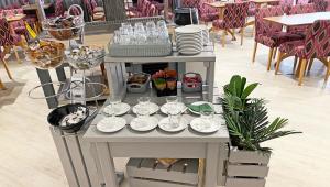 a table with plates and wine glasses on it at Magnuson Hotel Sandy Lodge Newquay in Newquay