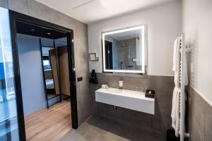 a bathroom with a white sink and a mirror at Park Inn by Radisson Reykjavik Keflavík Airport in Keflavík