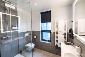 a bathroom with a toilet and a glass shower at Park Inn by Radisson Reykjavik Keflavík Airport in Keflavík