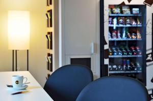 a table with two chairs and a drink refrigerator at B&B HOTEL Offenburg-Hbf in Offenburg