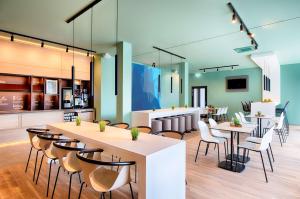 a restaurant with tables and chairs and a kitchen at B&B HOTEL Offenburg-Hbf in Offenburg