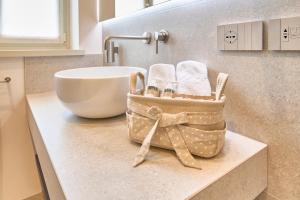 a bathroom counter with a sink and a basket of towels at Hotel Villa Cuserina in Cannobio