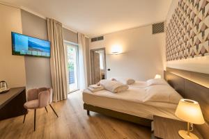 a hotel room with a bed and a tv at Hotel Villa Cuserina in Cannobio